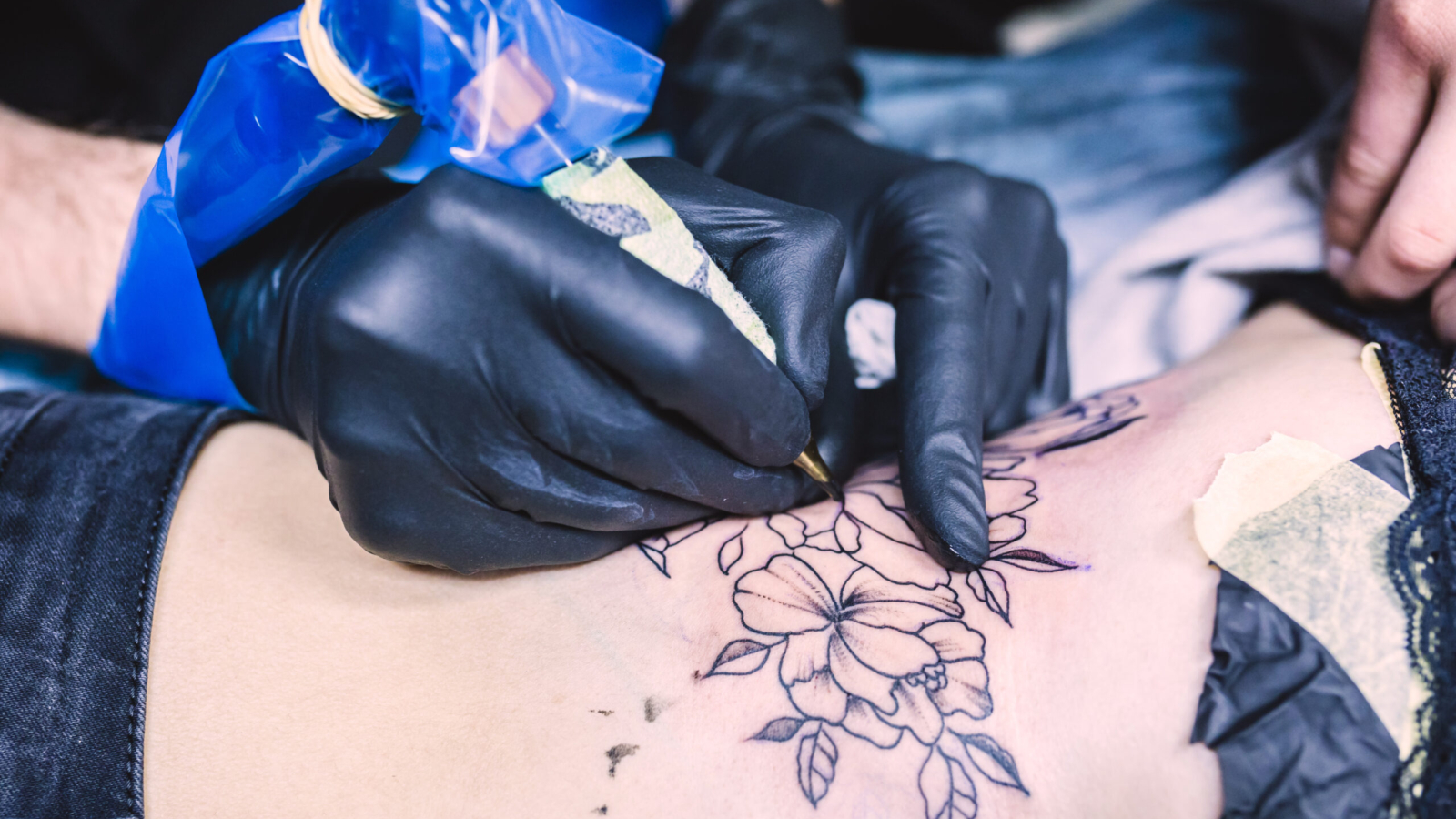 maos fazendo tatuagem com maquina